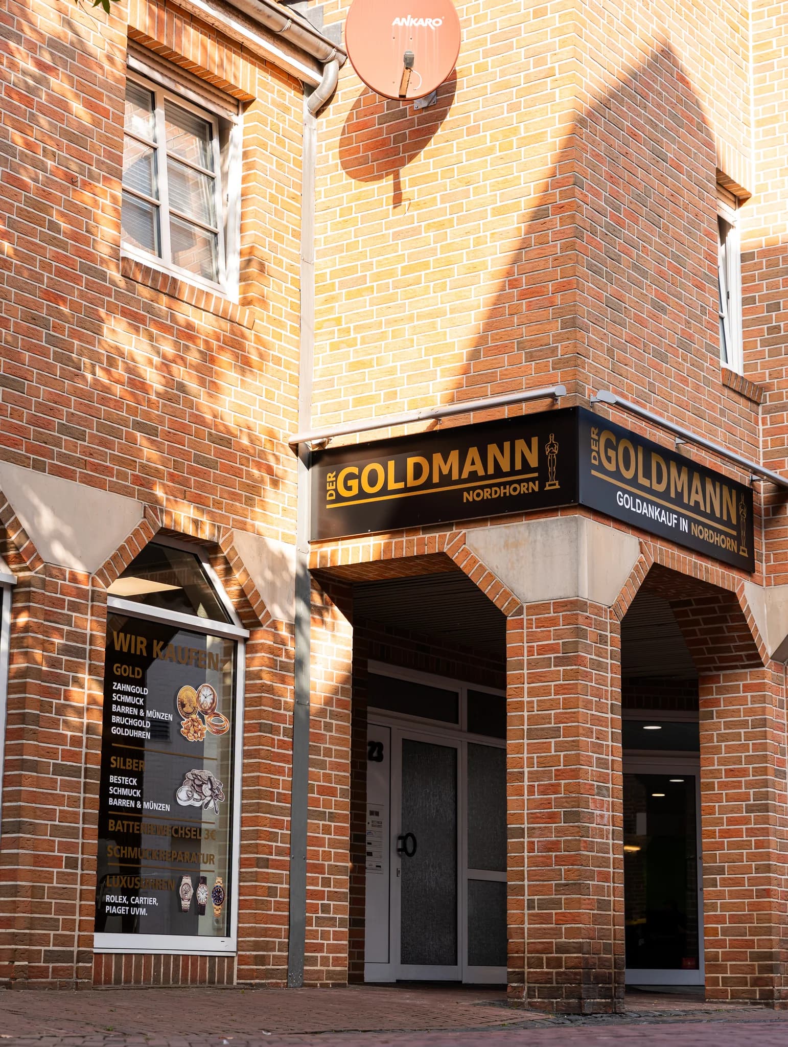 Eingang von Der Goldmann Nordhorn unter den Backsteinarkaden